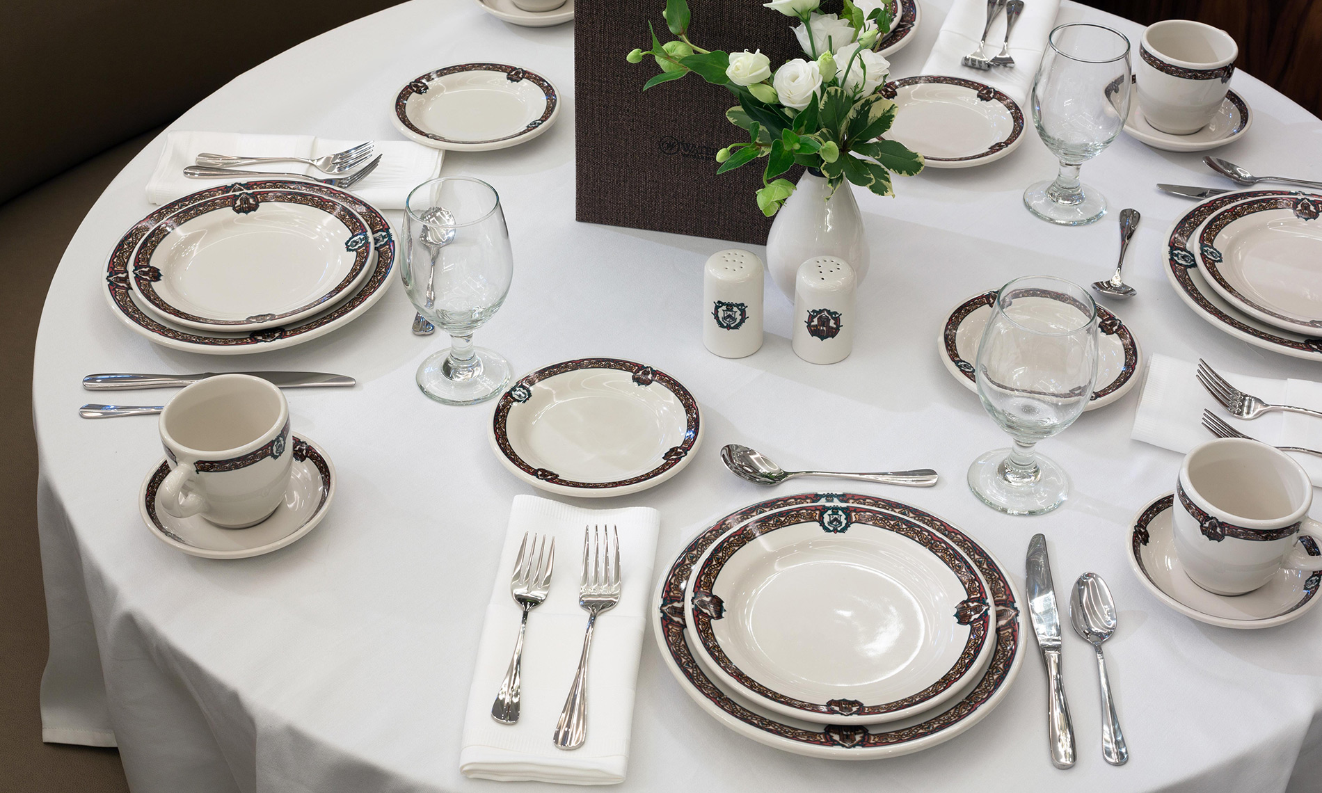 A table set with plate and cutlery set around a floral centrepiece