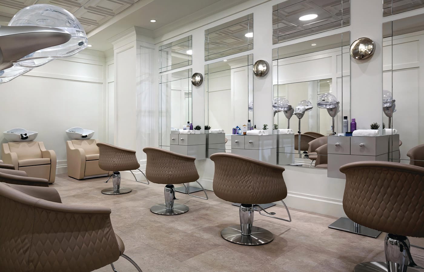 A row of hair salon chairs and blow dryers within Indulge at the Watermark at Brooklyn Heights