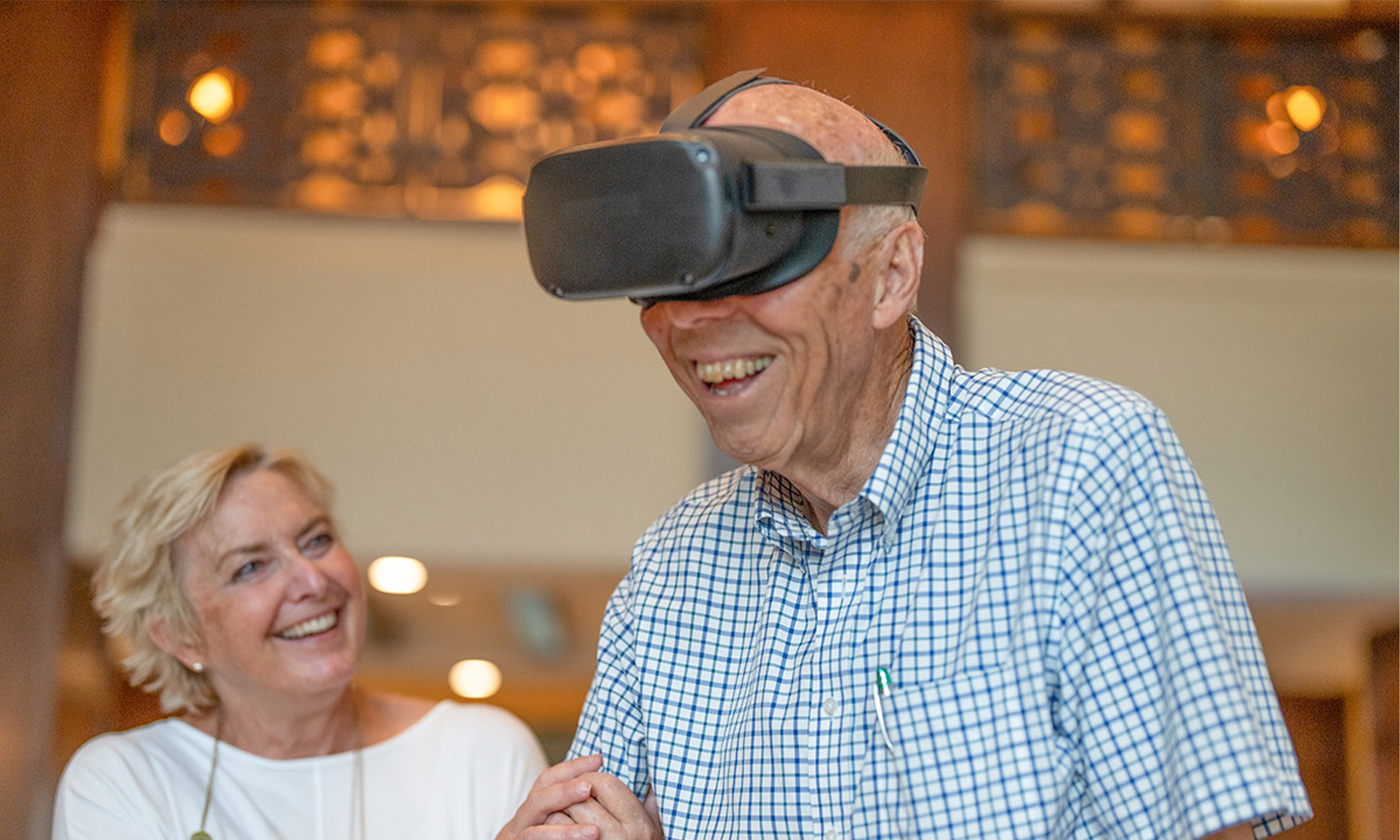Elderly woman with virtual reality goggles and controls 