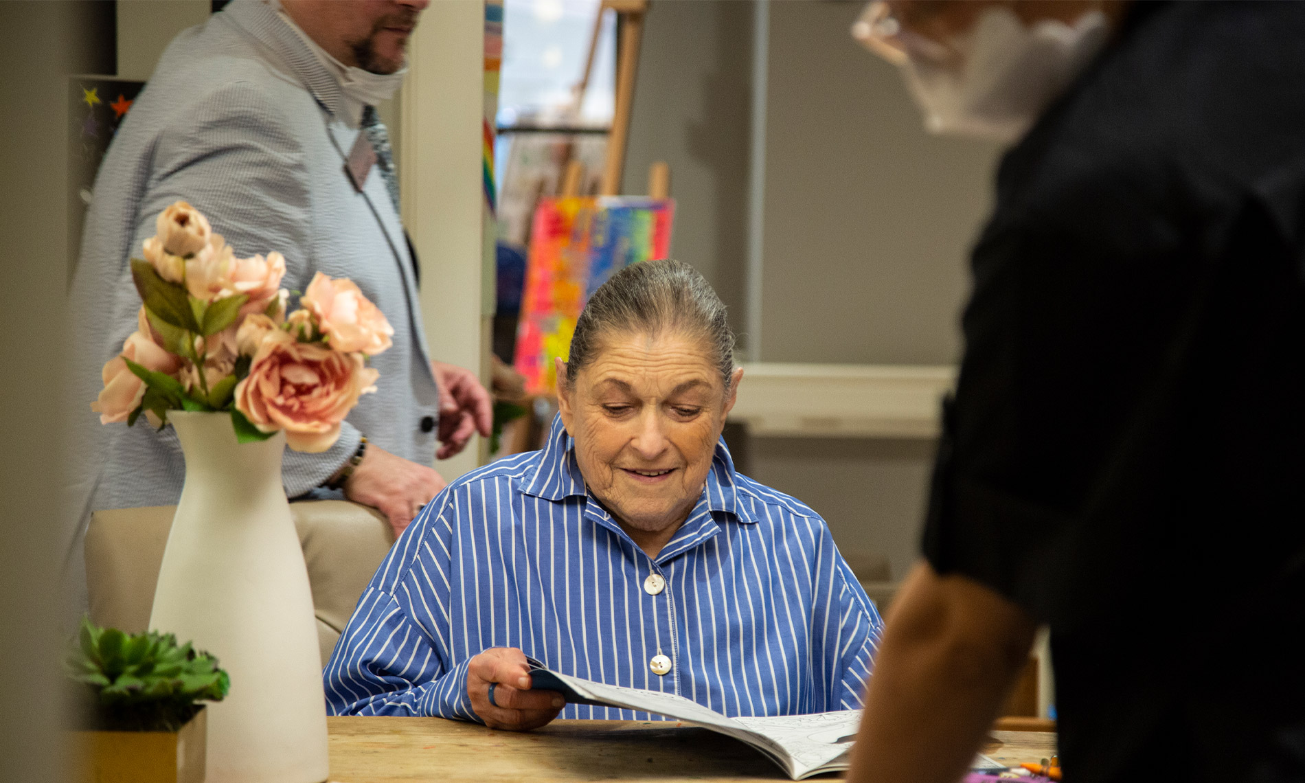 Elderly woman reading a book at a table