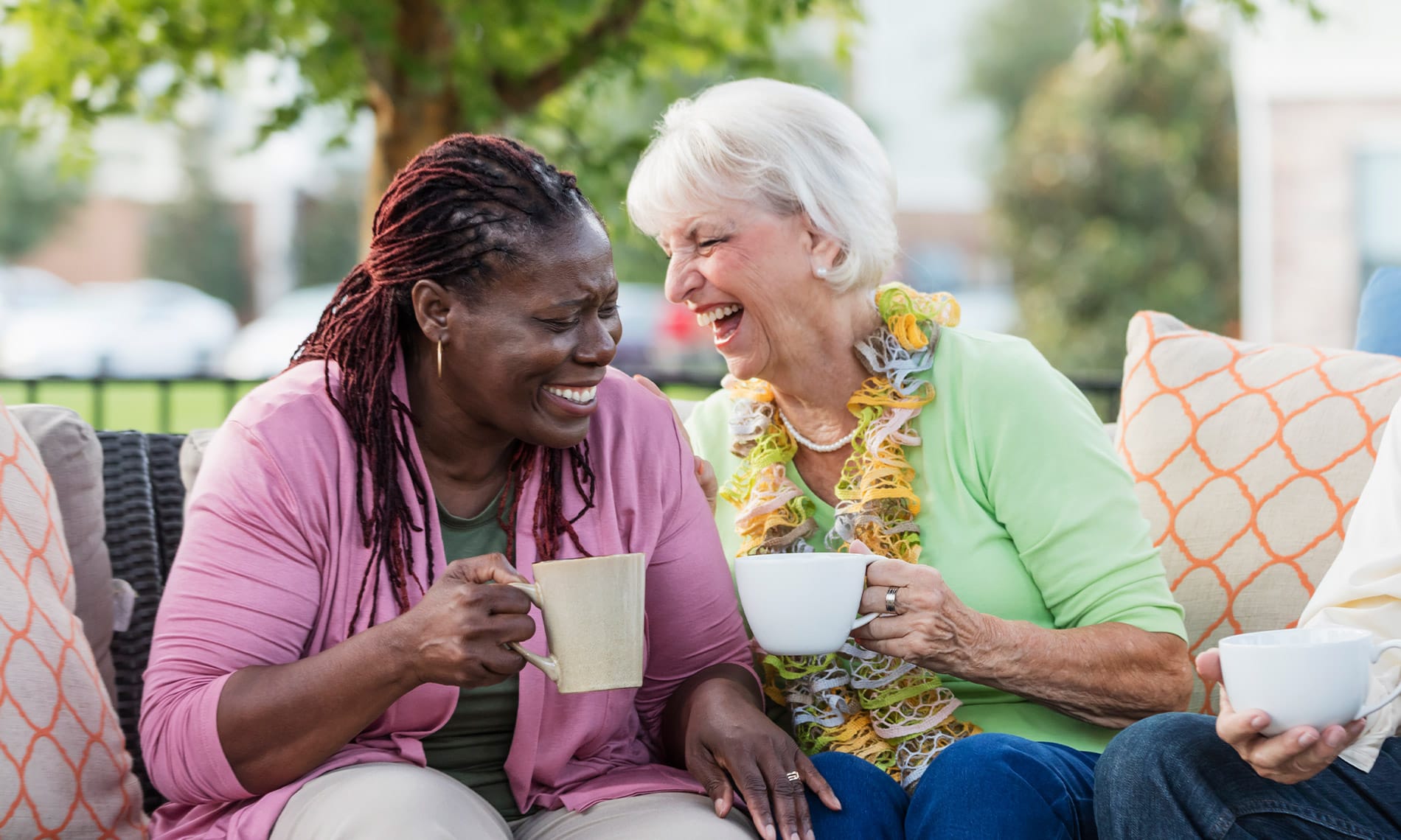elderly woman laughing over a cup of coffee