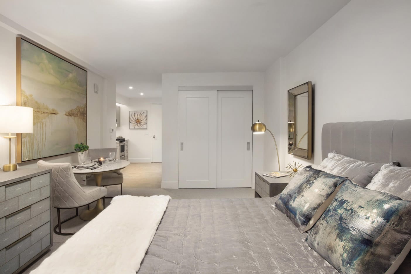 Brooklyn Heights Independent & Assisted Living Photo Gallery - Bedroom layout showcasing a neatly made bed, dresser, seating area and sliding door closet