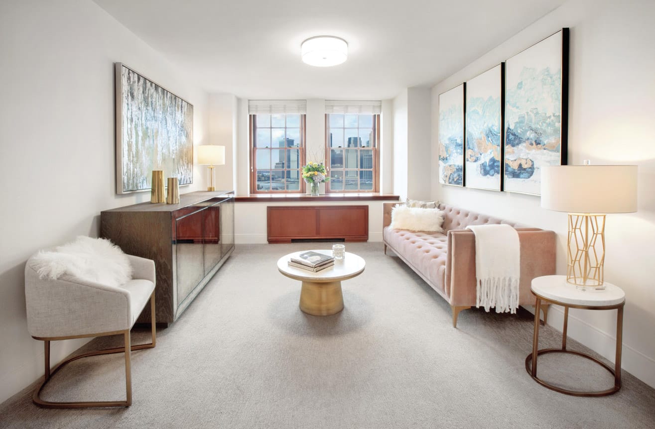 Brooklyn Heights Independent & Assisted Living Photo Gallery - living space layout featuring several pieces of tasteful artwork, several chairs with matching end tables, and a view of New York through the mahogany framed windows