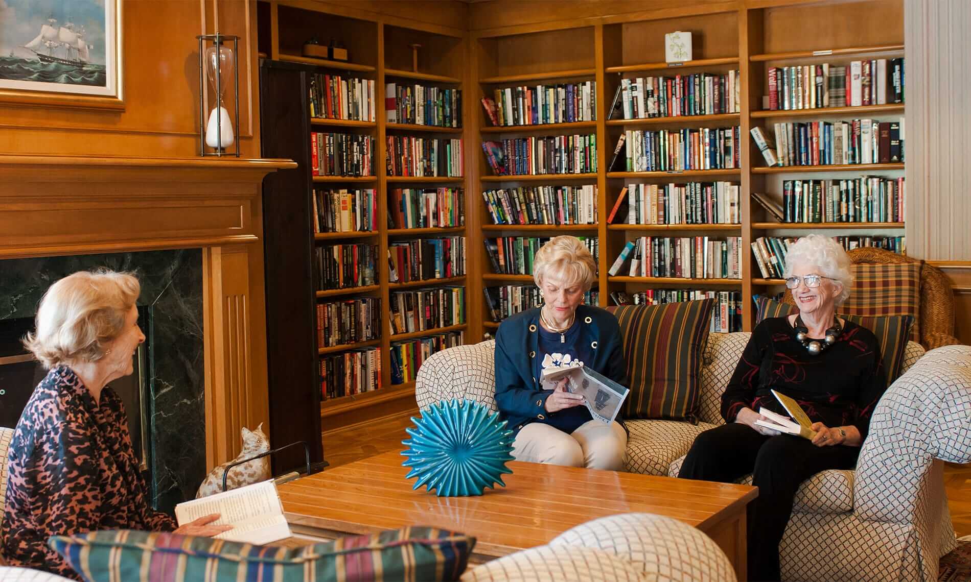 Group of elderly women sitting in a library laughing
