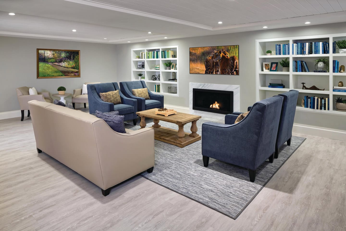 Memory Care Photo Gallery - A communal space exclusively for the Memory Care residents at the Watermark at Brooklyn heights featuring built in cubbies along the wall, vibrant artwork, a couch, four chairs and a wooden coffee table