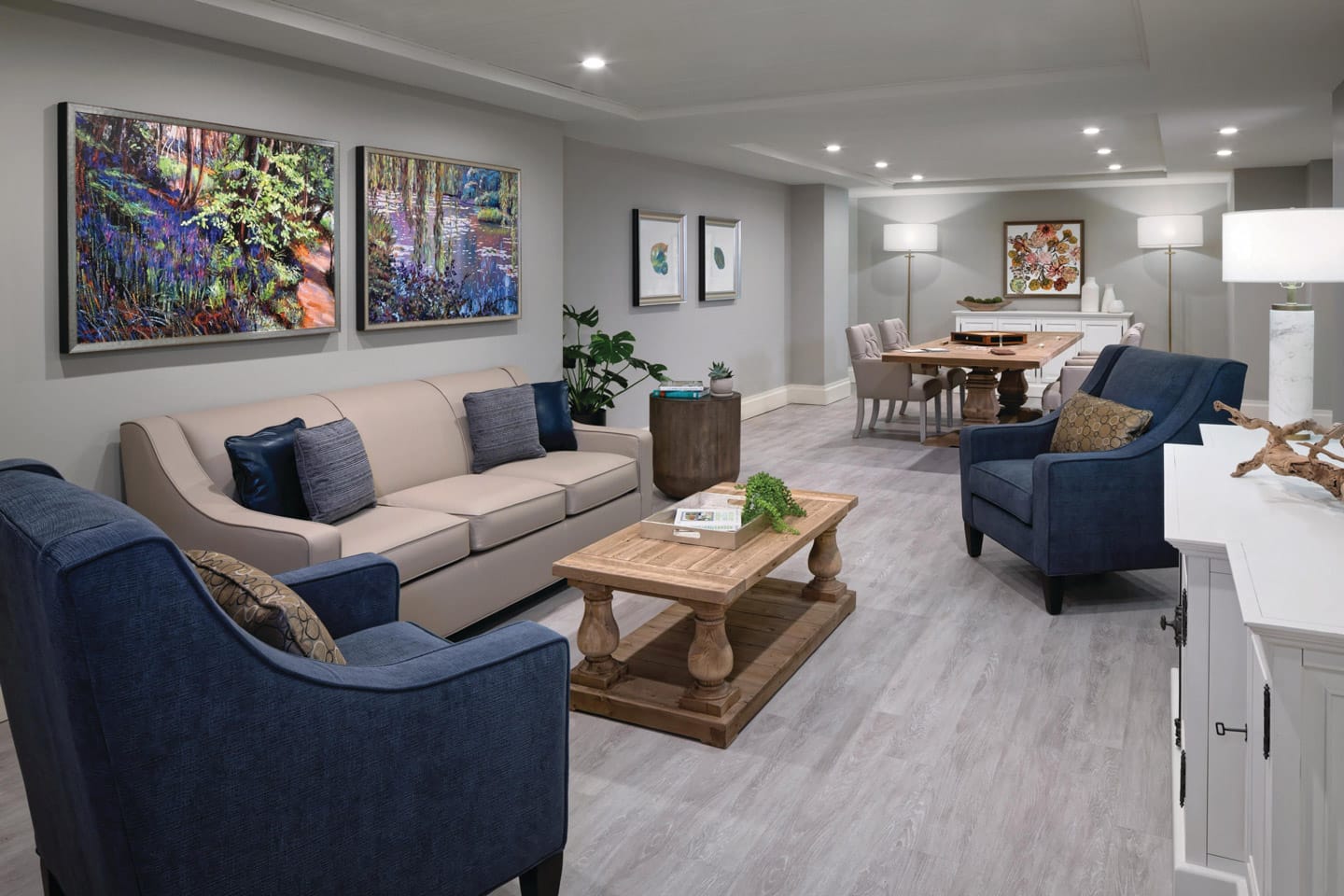 Memory Care Photo Gallery - A quiet seating area featuring vibrant art work, a couch, several chairs and a coffee table ideal for a quiet conversation between Memory Care residents and their loved ones