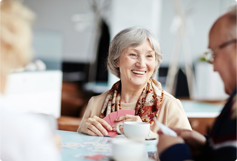 group of seniors enjoying a cup of coffee and laughing
