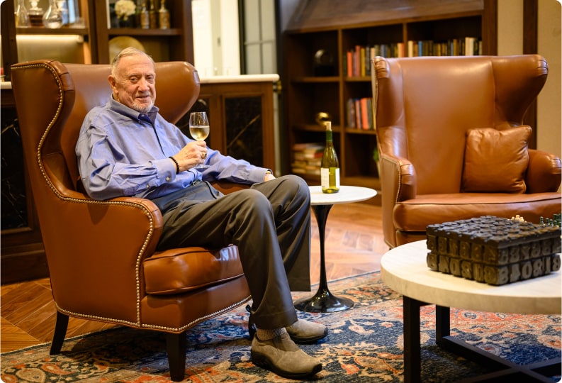 elderly gentleman enjoying a glass of white wine
