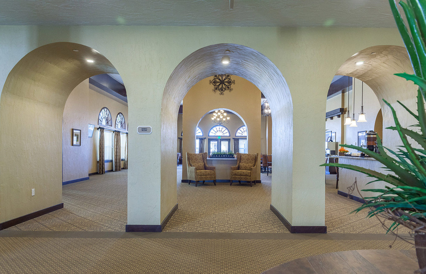 three arched doorway leading into a vast hall with two armchair