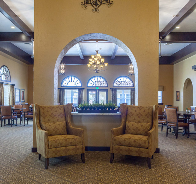 two armchair in the center and what appear to be a hall behind the narrow wall of which the armchairs are against