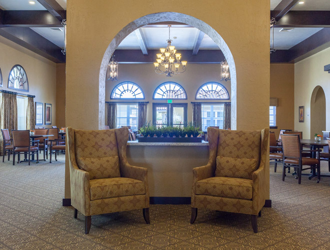 two armchair in the center and what appear to be a hall behind the narrow wall of which the armchairs are against