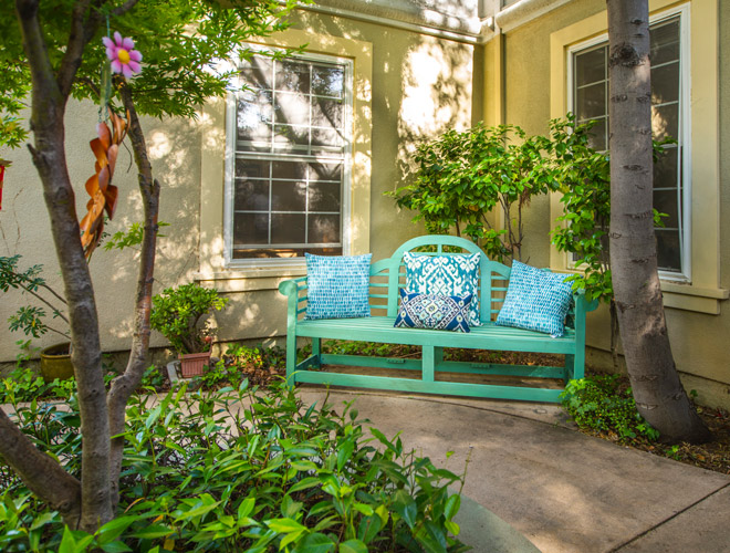 A turquoise bench in front of house