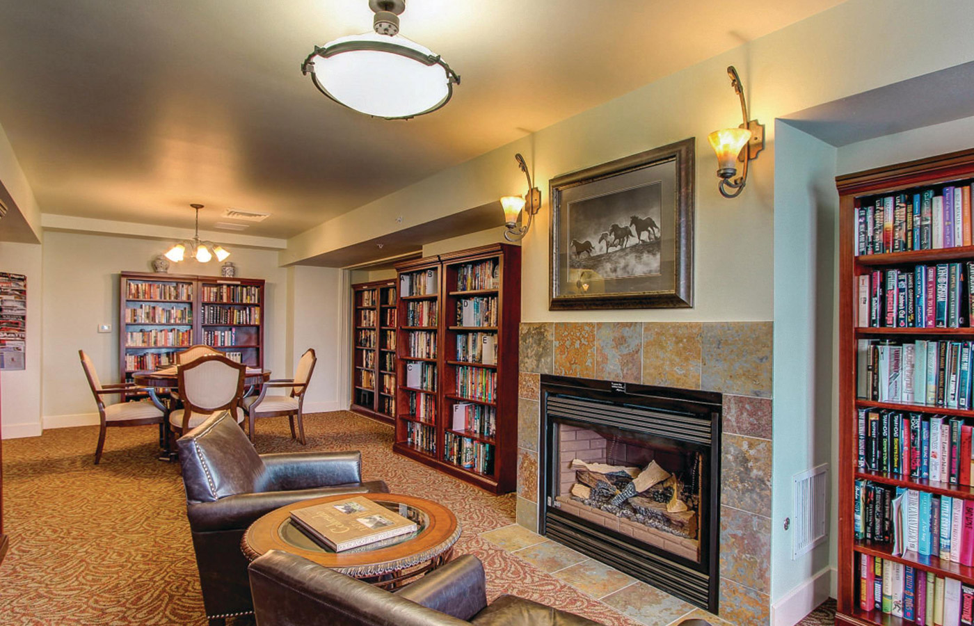 A brick wall with a fireplace surrended by book shelves and chairs