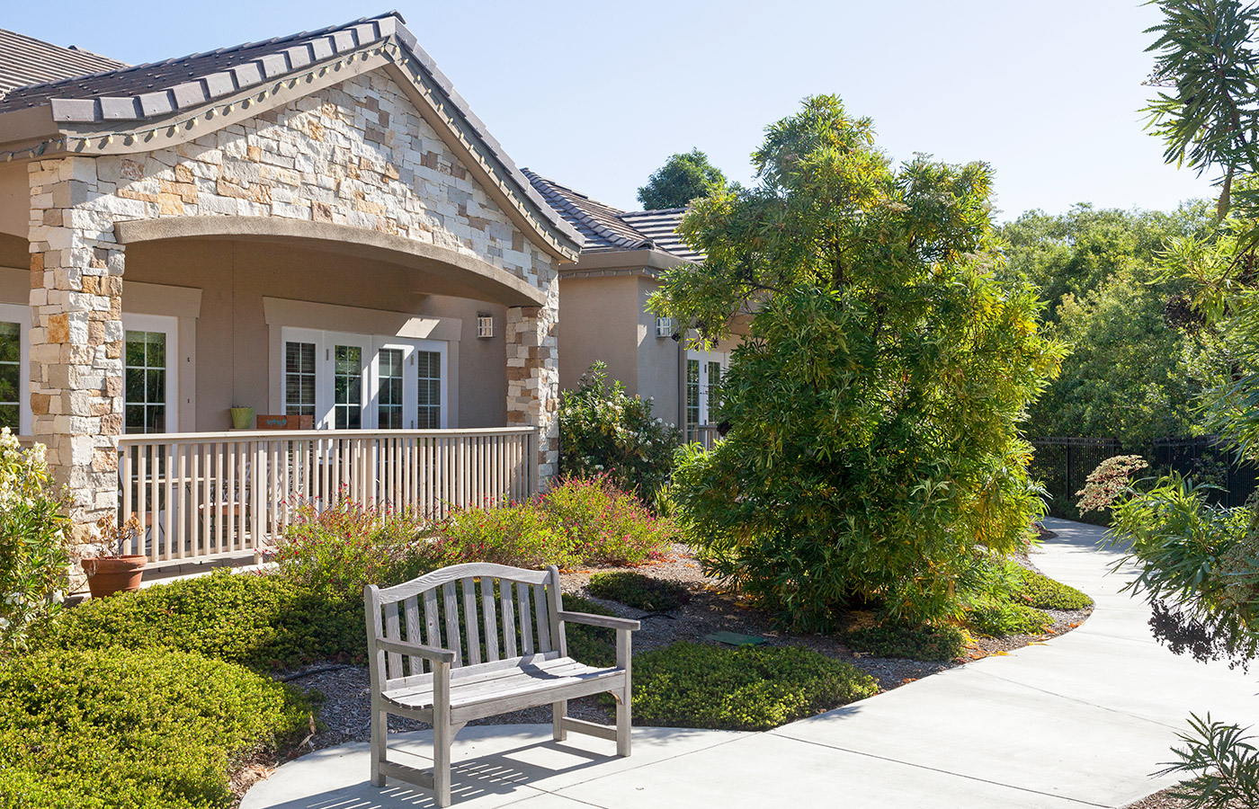 A Walking path, with a bench to sit in front of the residence 