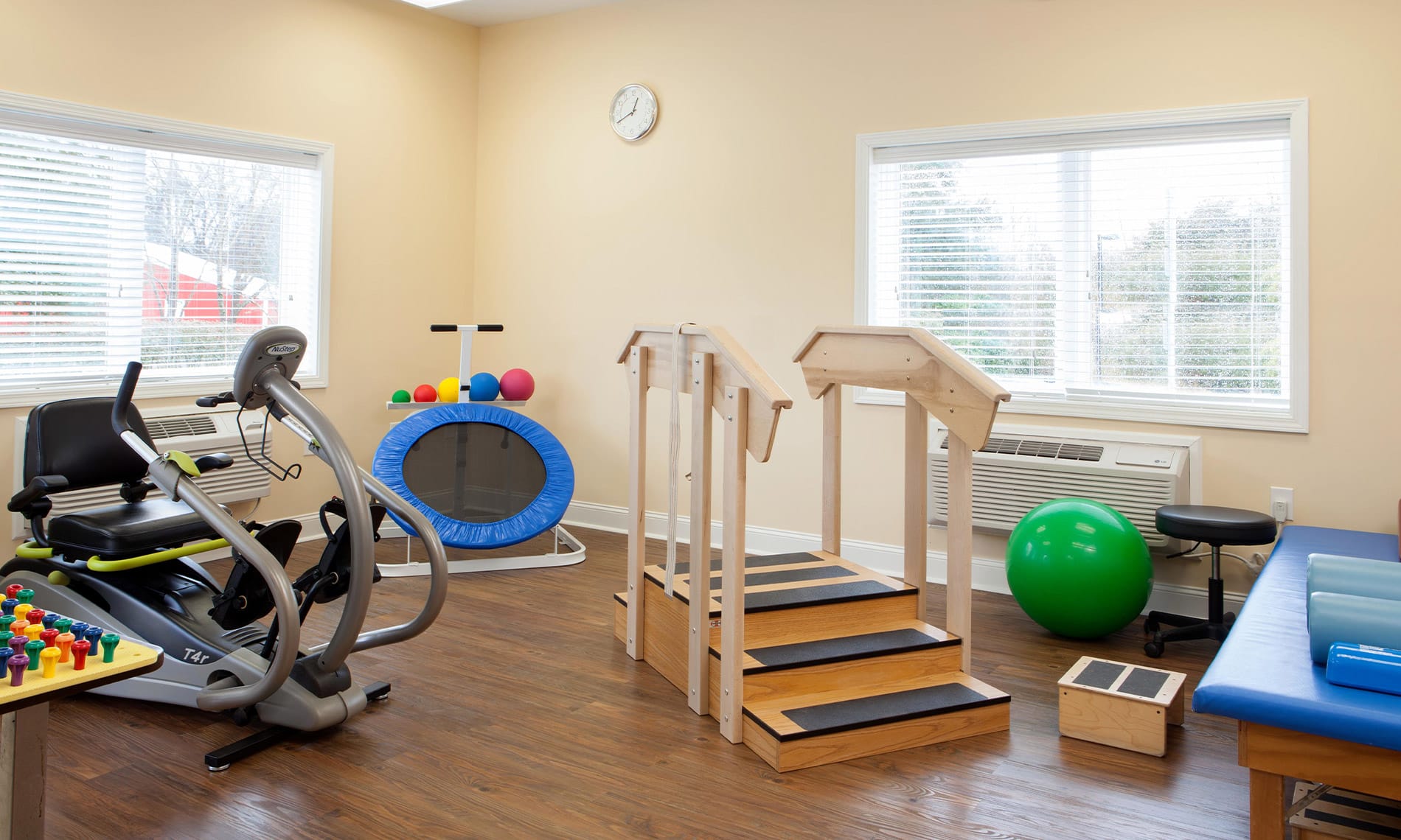 An assortment of fitness equipment including a bike, trampoline and stairs with railing found on-site at the Fountains at Albemarle