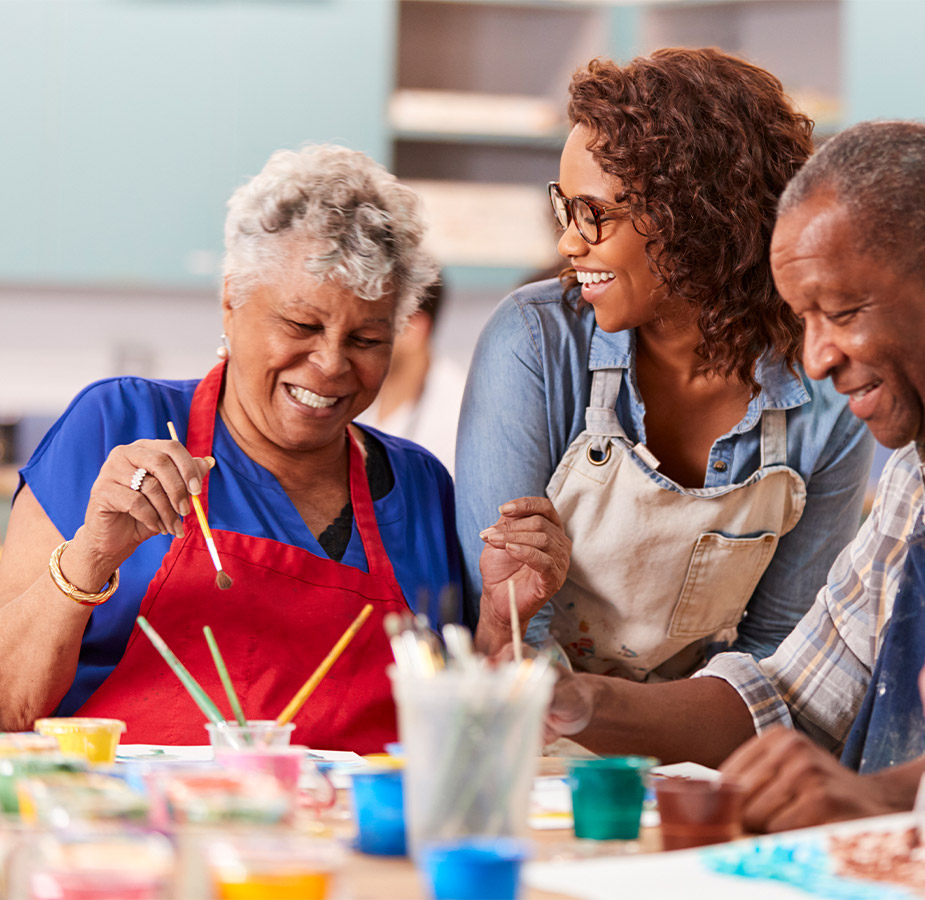 A group of seniors partaking in a painting workshop with an instructor