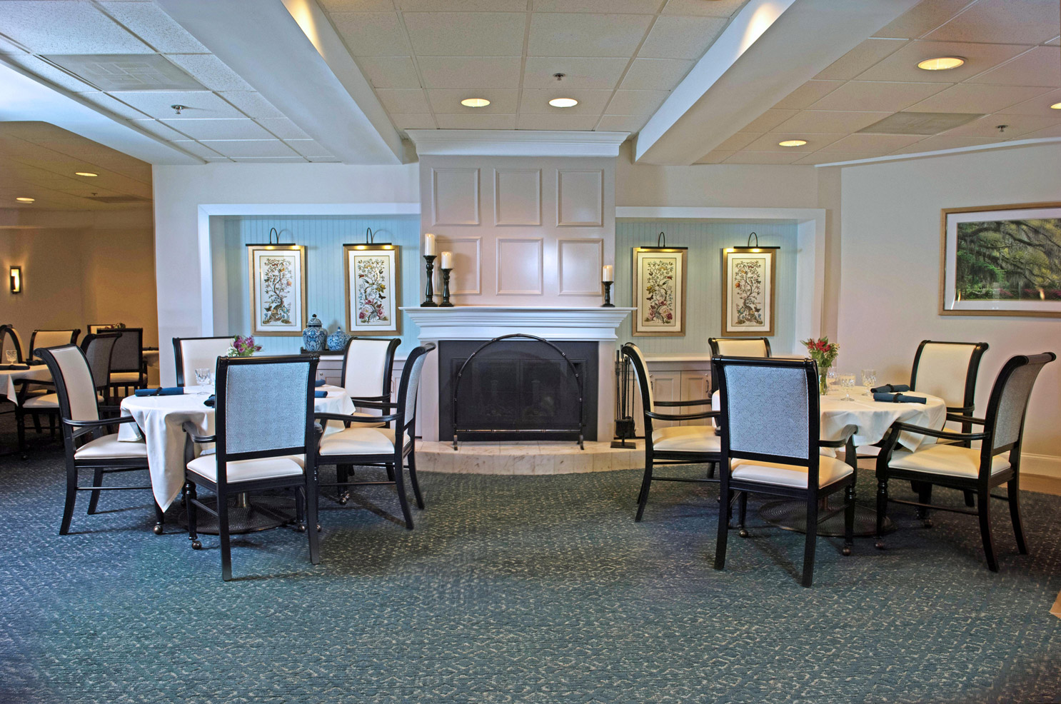 Two tables with four place settings framing a wooden burning fire in the Parlour at The Fountains at Albemarle