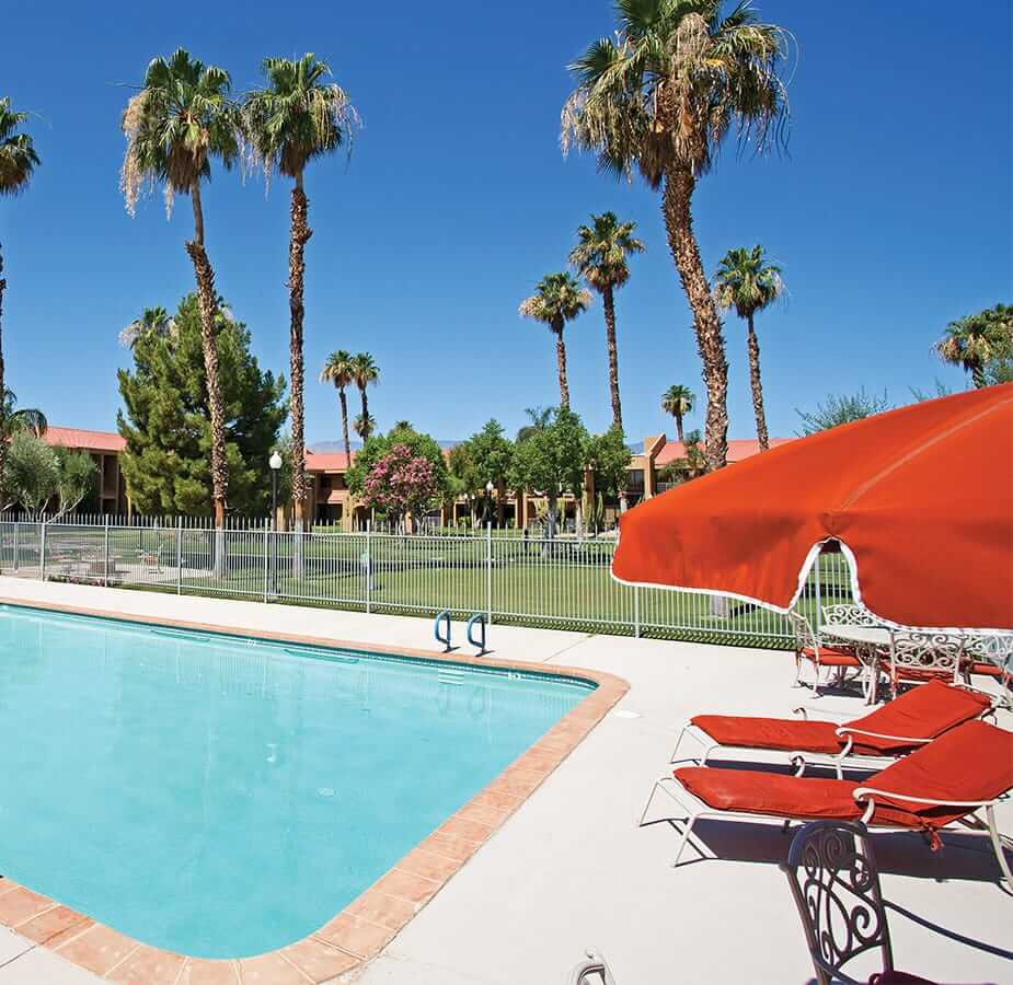 An outdoor pool and red lounge chairs at the Fountains at the Carlotta, Emeryville CA