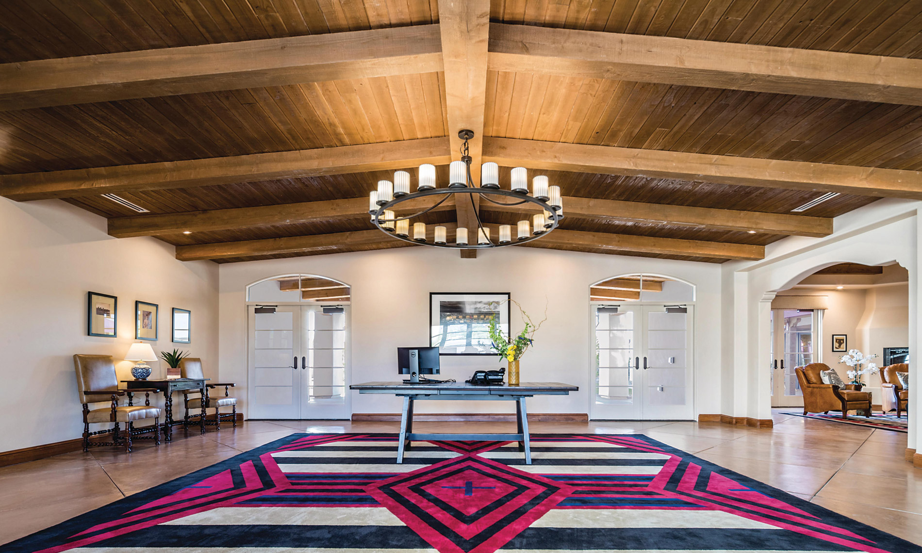 A grand foyer with a red, white and dark blue striped rug in a well lit room