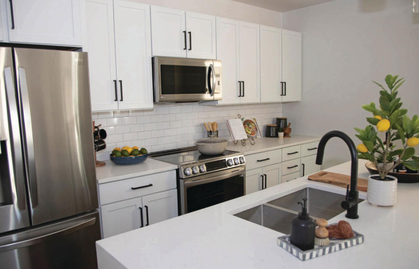 A modern kitchen featuring white cabinetry and stainless steel appliances in a residence found at The Hacienda at the River