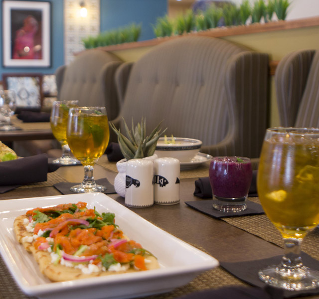 A table set with glasses of beer and a chef prepared meal at The Hacienda at the Rivers