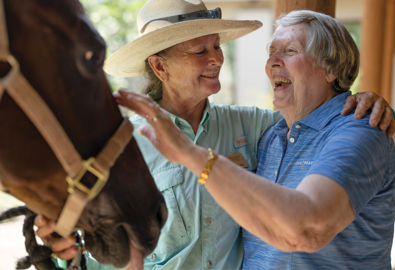 A resident and a staff member in the stables at The Hacienda at the Rivers