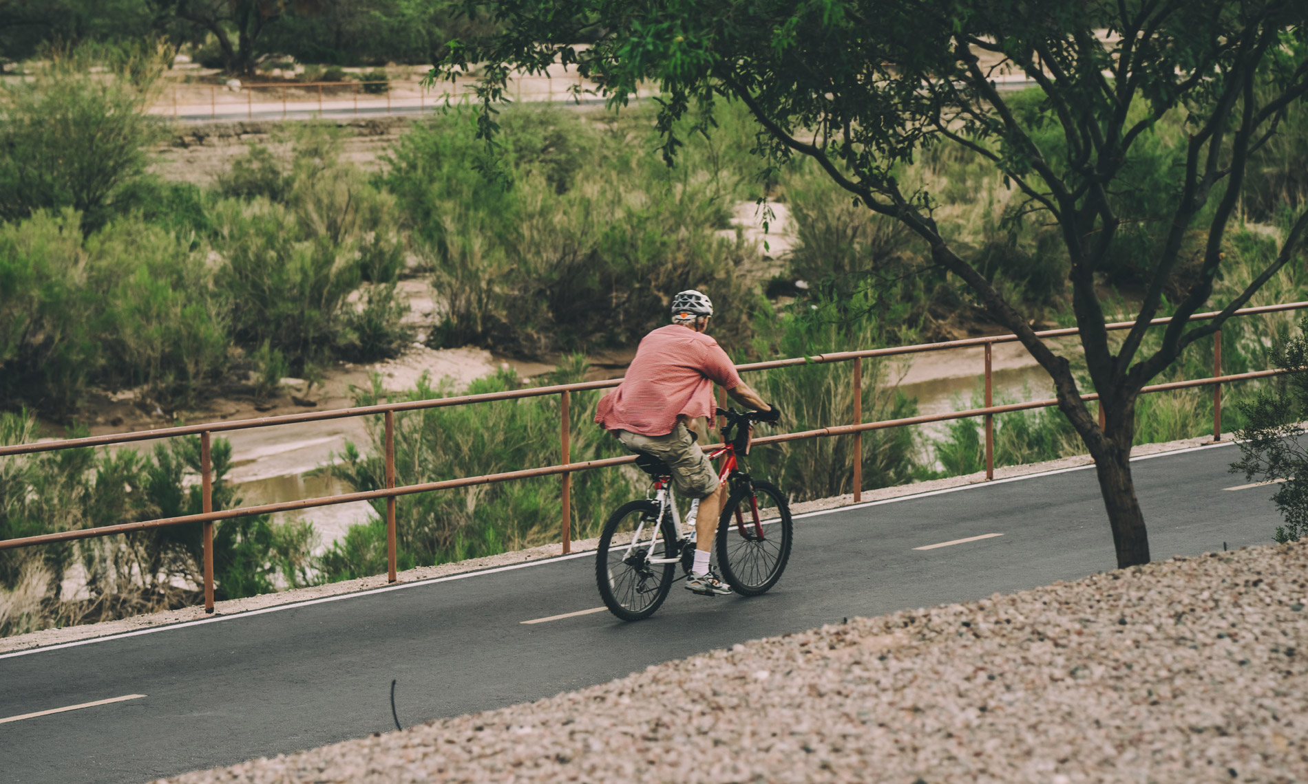 A resident enjoying a bike ride on an outdoor pathway in Tucson, AZ