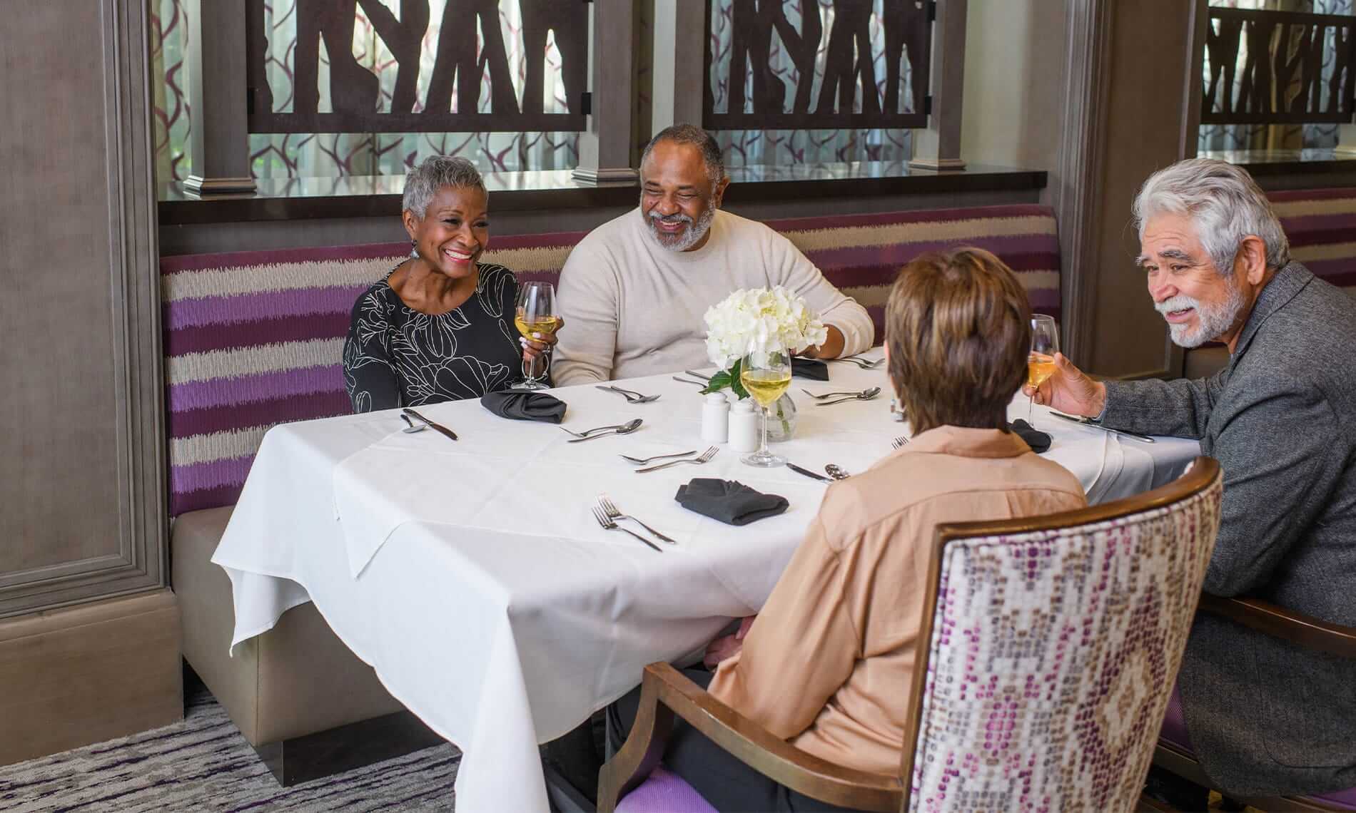 A group of residents from the Preston of the Park Cities enjoy wine and appetizers at one of the on-site eateries