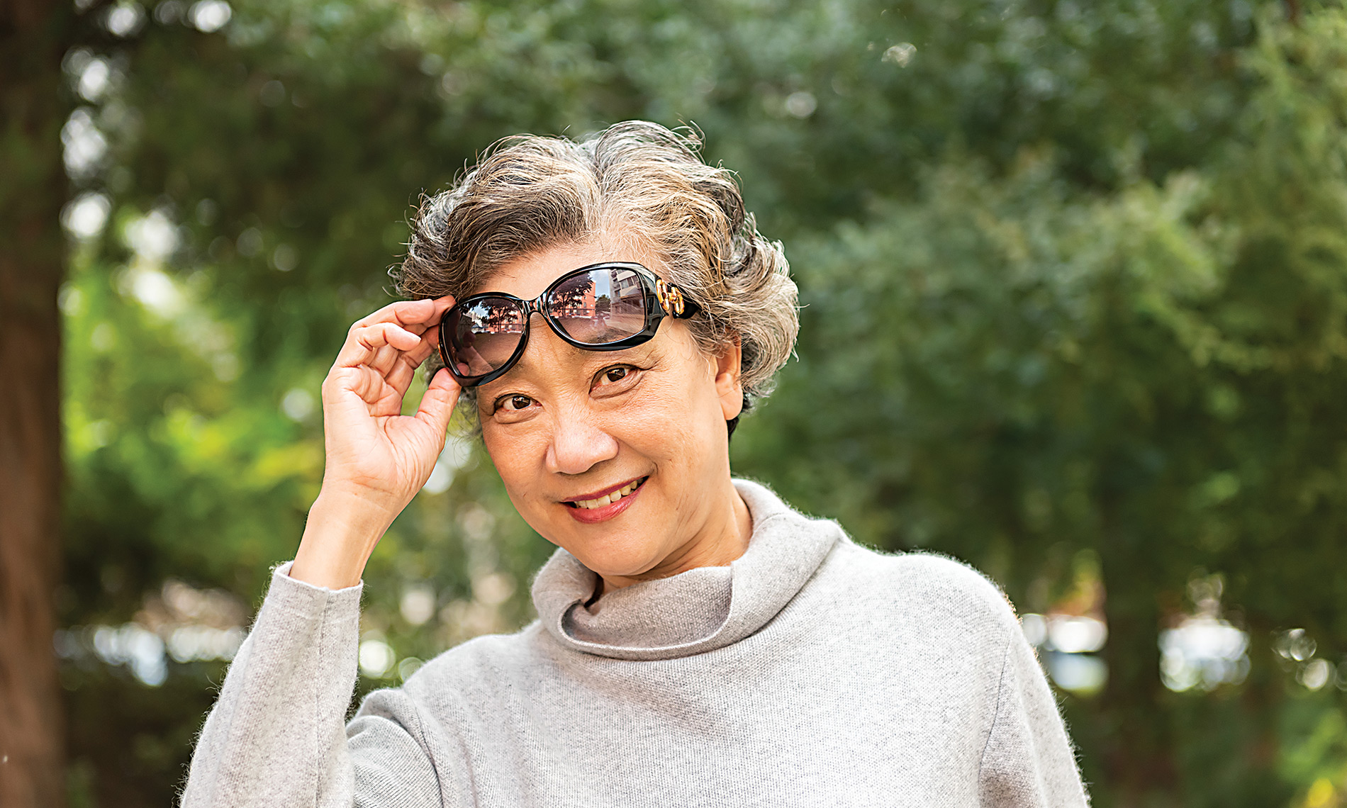 A resident lifts glasses up and smiles.