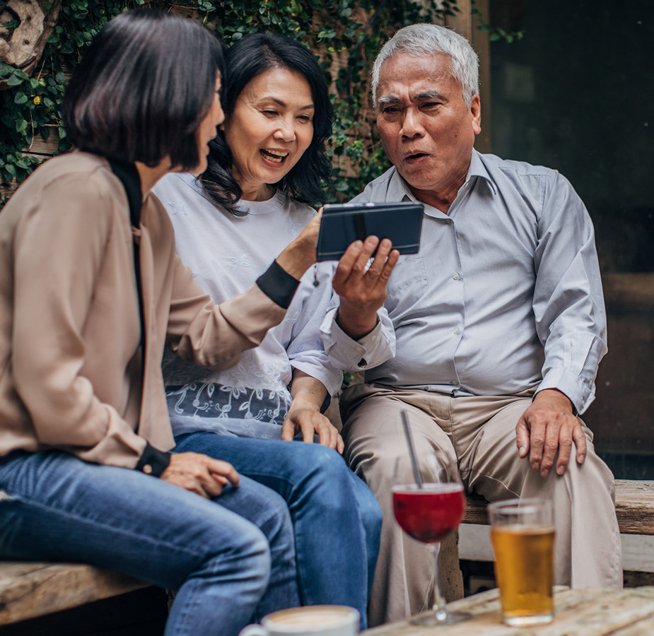 Three people looking at a phone.