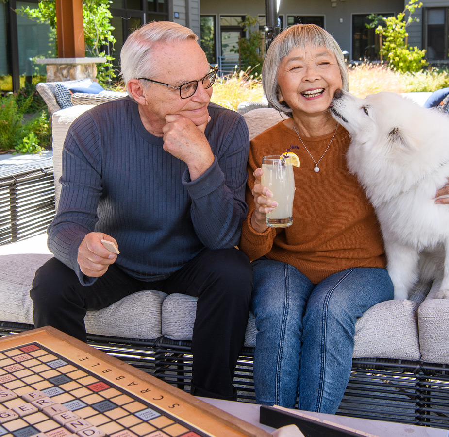 Residents enjoying a game of chess sitting next to their dog