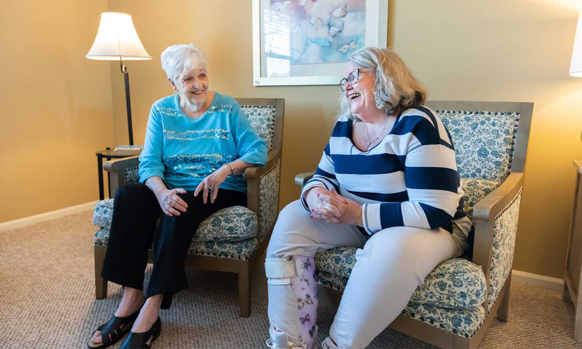Female residents sitting on the couch laughing in a resident apartment
