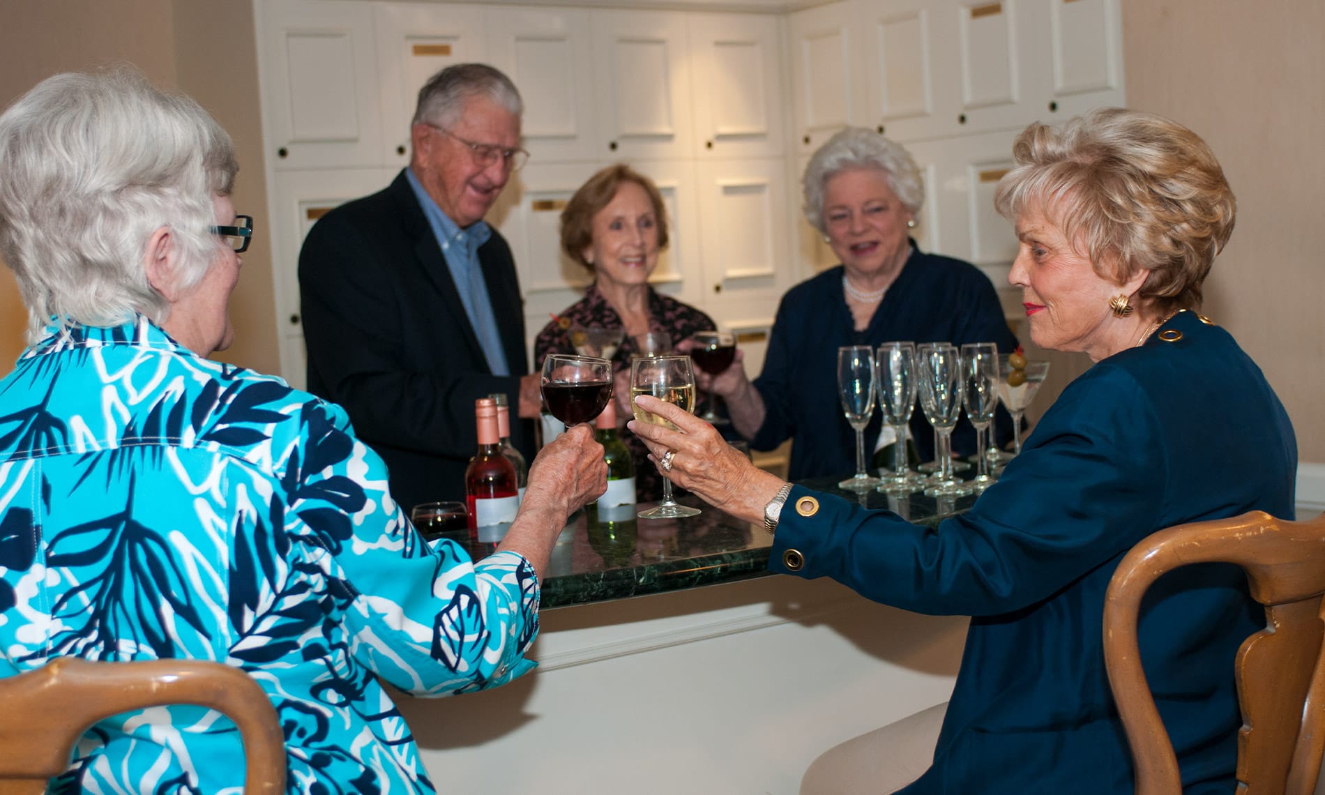 A group of residents enjoying red and white wine during a social evening as part of the independent living program 