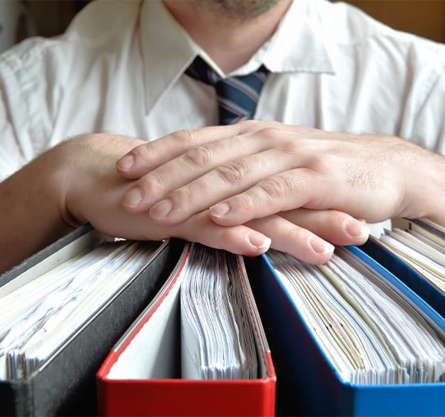 A member of the local emergency preparedness coalition holding three binders outlining several different procedures the coalition oversees