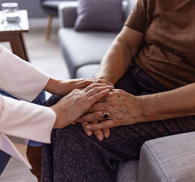 Cropped shot of a senior woman holding hands with a hospice nurse