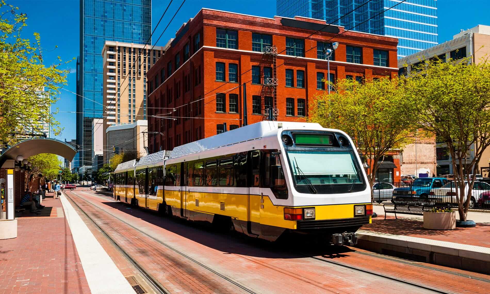 Wide angle view of a DART light rail train at a station in downtown Dallas.