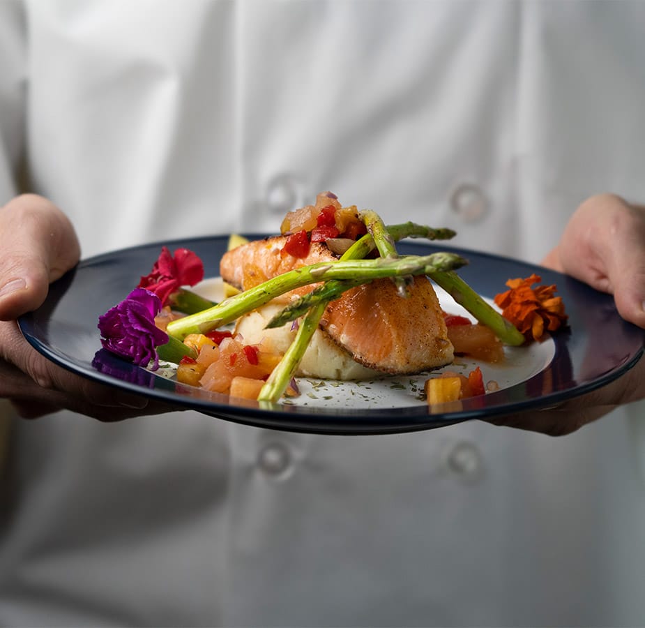 A chef holds a plated dish
