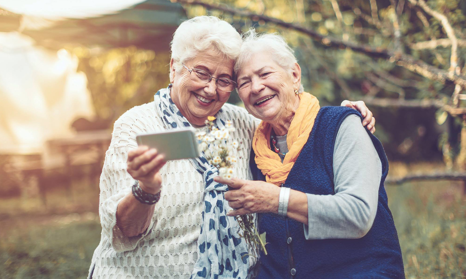 Glasses on a phone and newspaper with a cup of coffee in the background