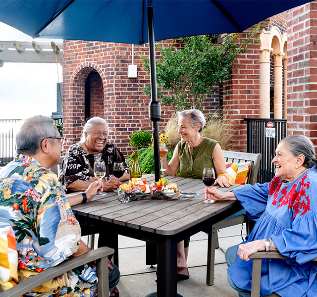 A group of seniors enjoying snacks and beverages on a patio