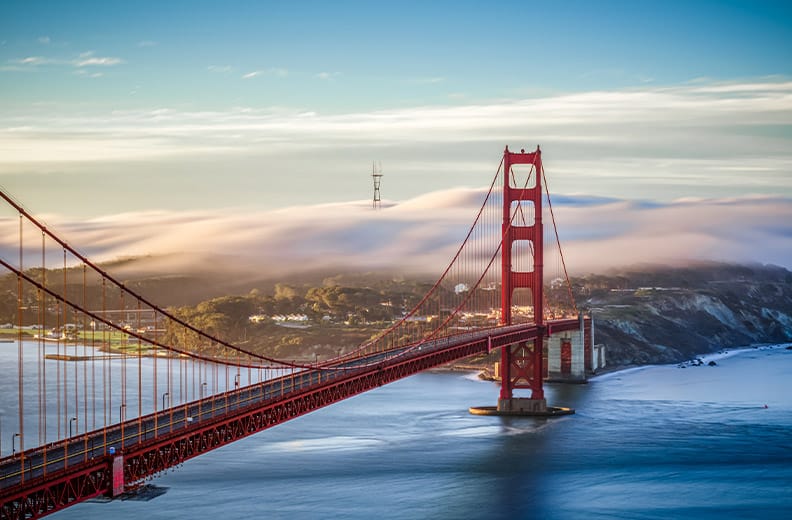 A view of the Golden Gate bridge and San Francisco with cloud cover early in the day