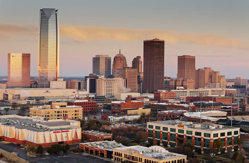 Aerial shot of Oklahoma City at sunrise, looking across Bricktown towards the downtown skyline.