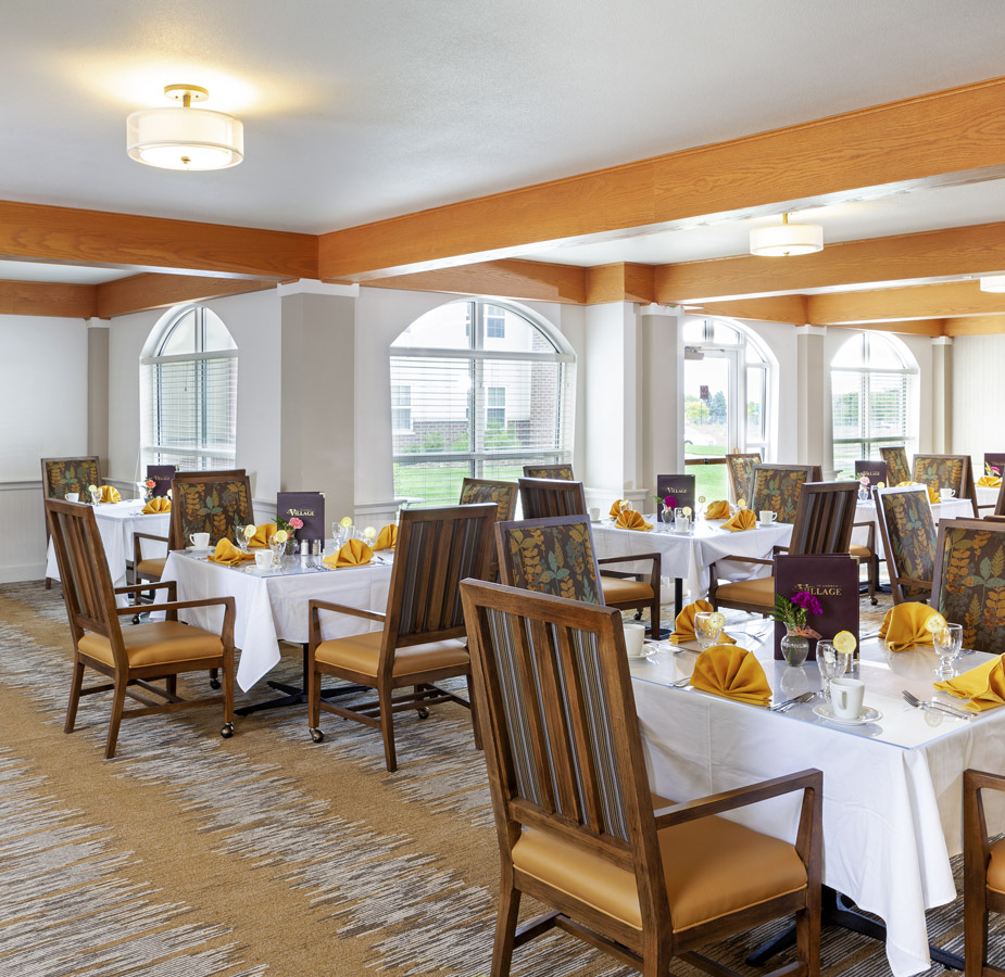 Dinning st Andrew An elegant dinning table set with an array of silverware and yellow aprons