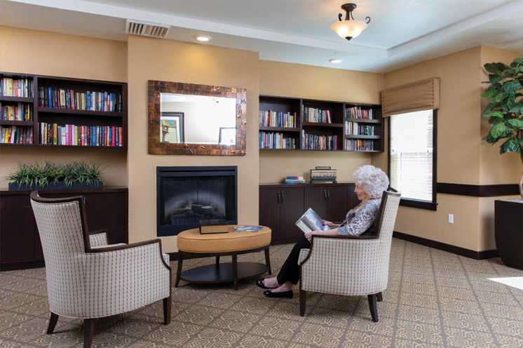 A lady reading in front of a fireplace