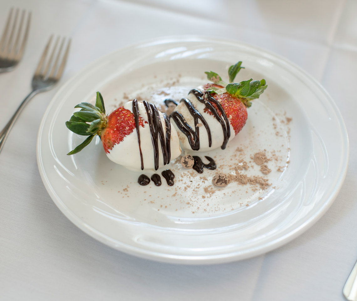 Strawberries dipped in white chocolate with a dark chocolate drizzle on top