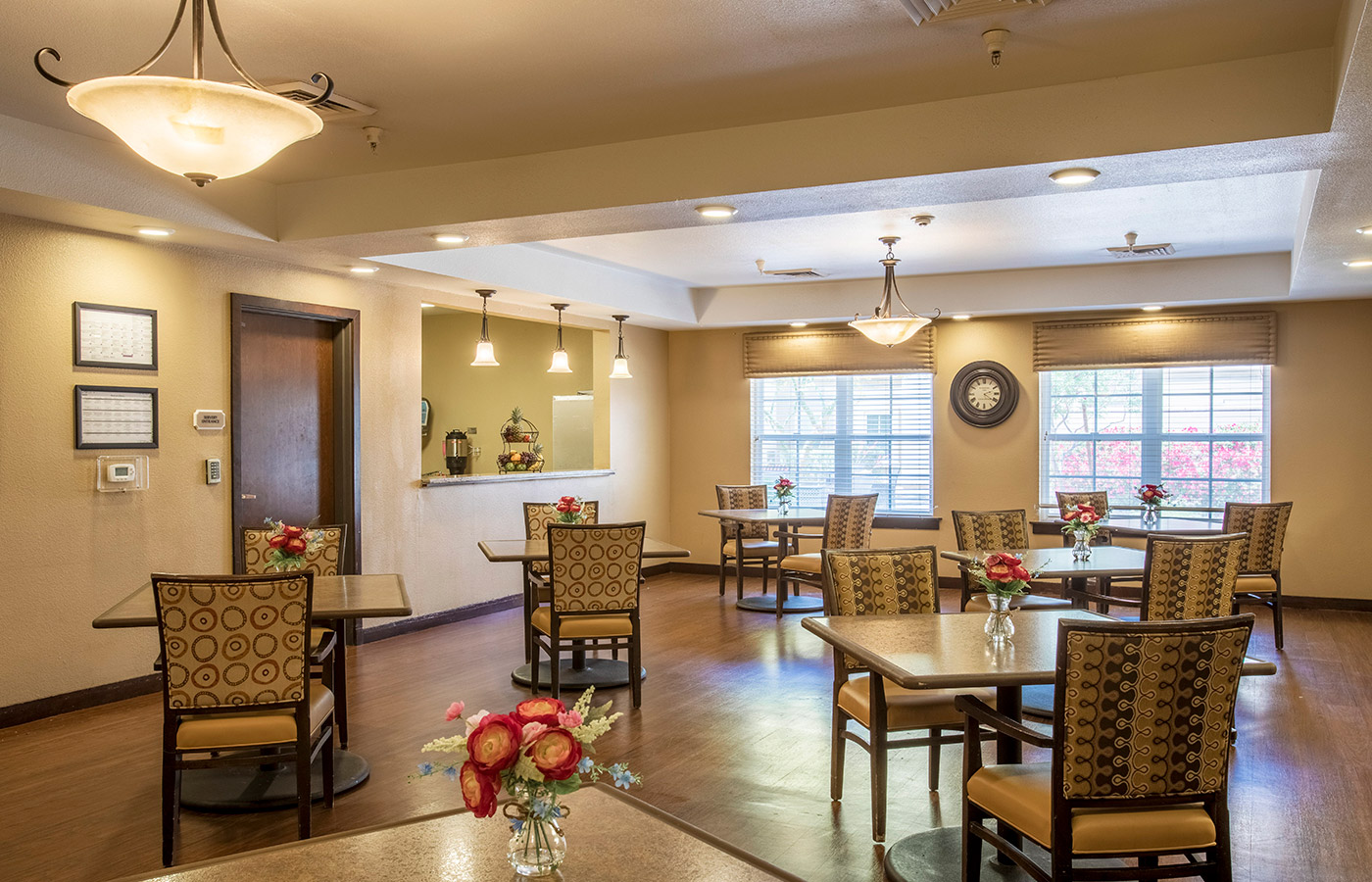 The dining room including dinner tables and large windows on the back wall 