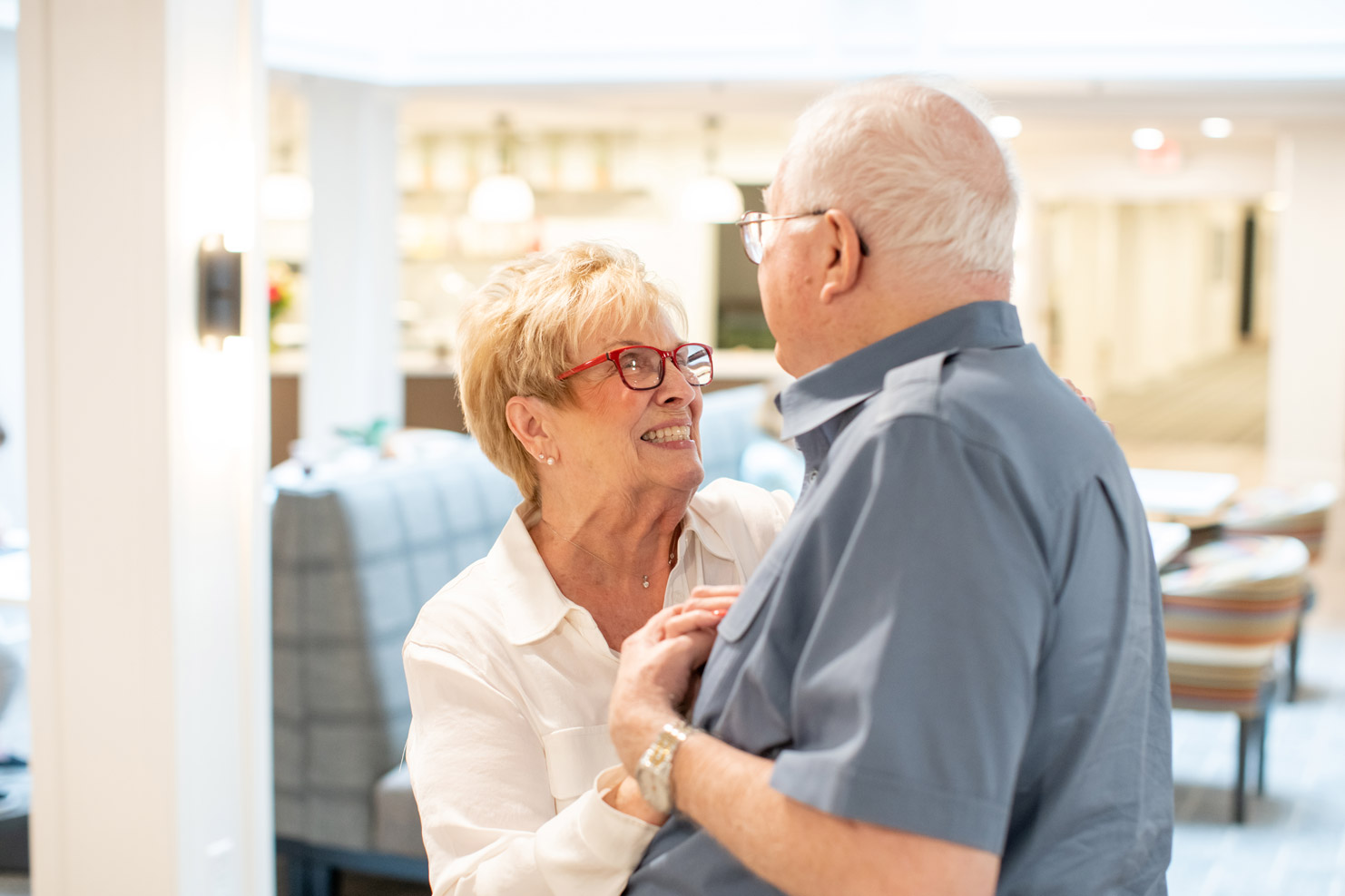 An elderly couple lovingly looking into each others eyes while dancing