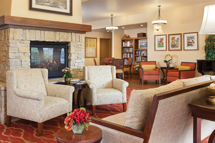 Hall with armchair, fireplace and bookshelf in the back 