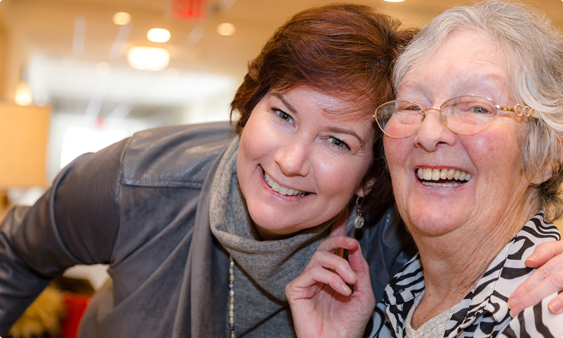 An elderly woman and her daughter laughing An elderly woman and her daughter laughing