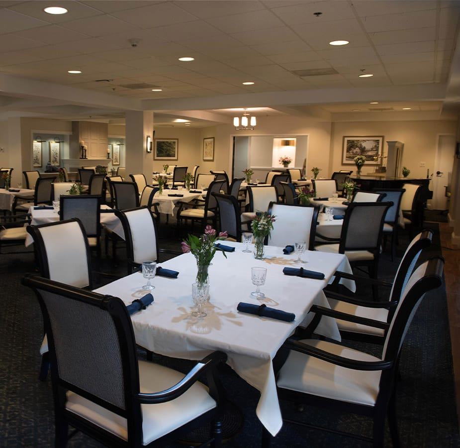 The Fountains at Albemarle Dining A dining room on-site at the Fountains at Albemarle featuring leather backed chairs and tables with white linens