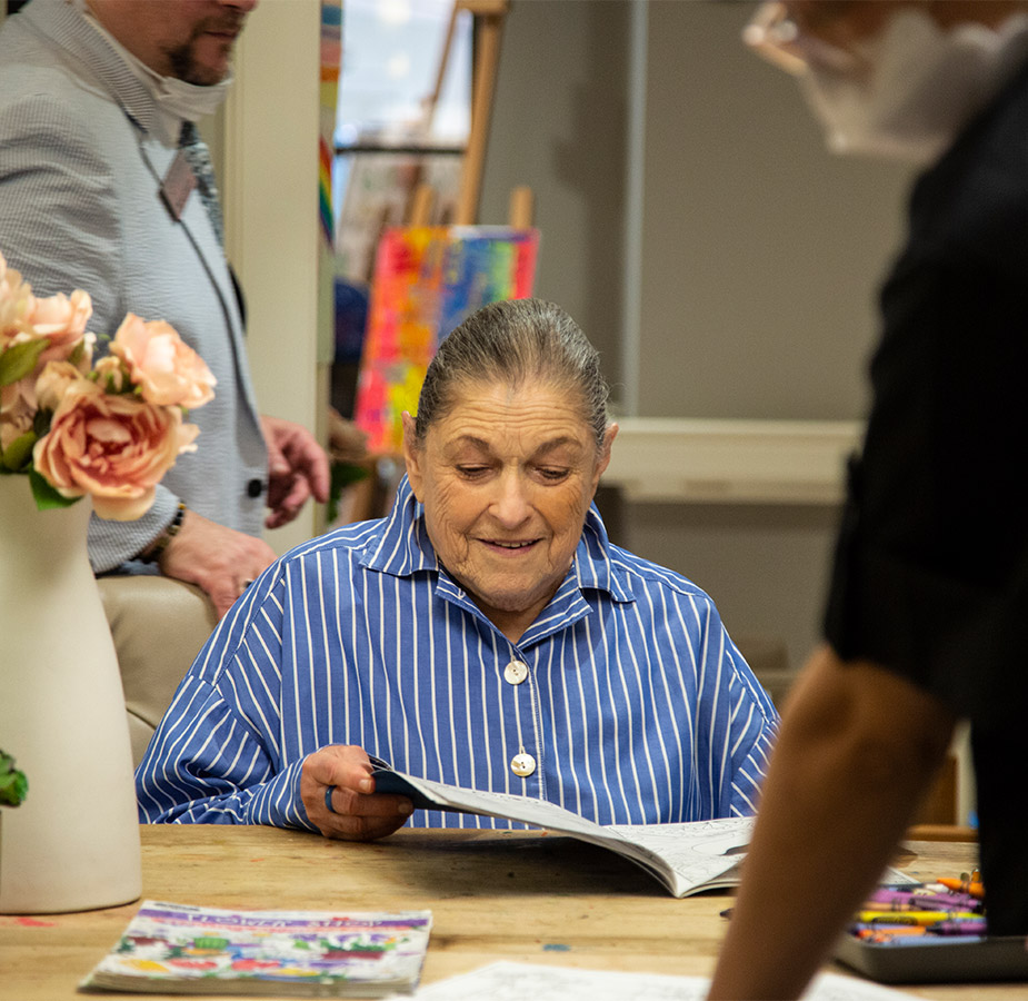 Elderly woman reading a book at a table Elderly woman reading a book at a table